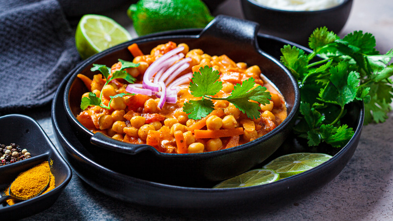 Chickpea curry black bowl with red onions cilantro