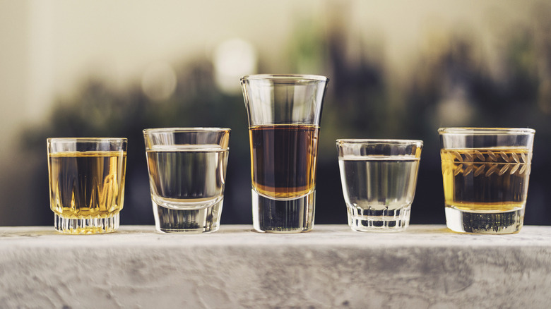 Various liquors in shot glasses on counter 