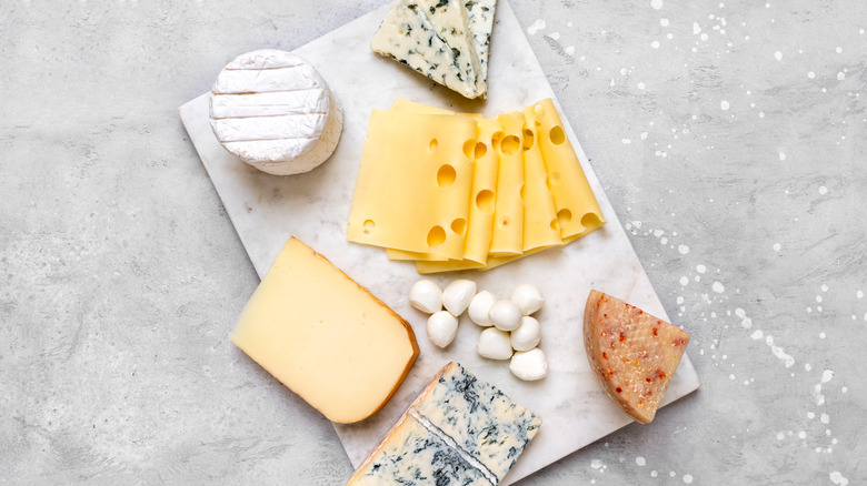 Various cheeses on marble cutting board