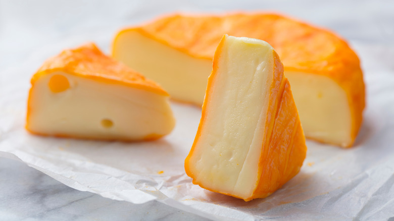 washed rind cheese wheel cut into wedges