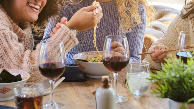 friends enjoying wine and ramen