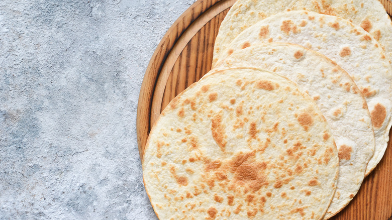 cooked tortillas on wooden tray