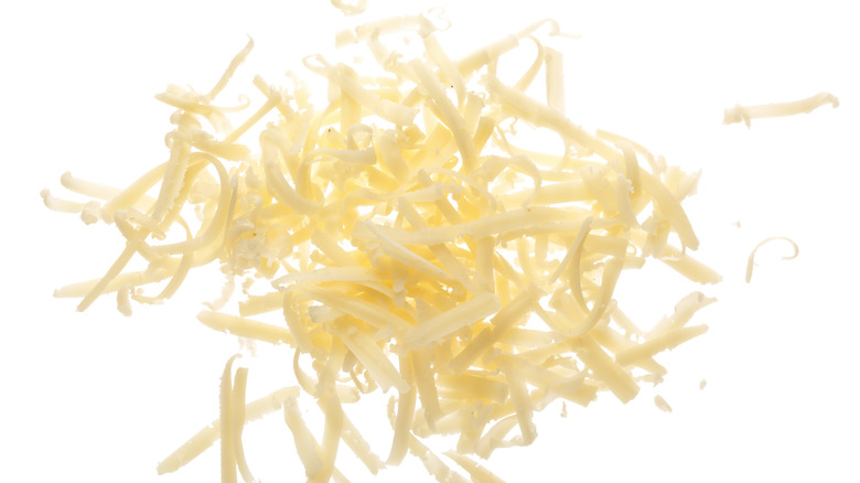 Grated cheese on white background 