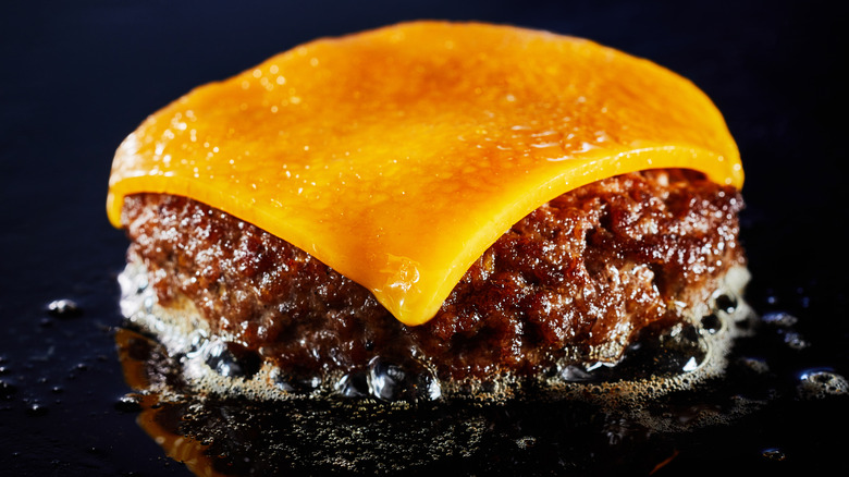 cheeseburger patty on griddle