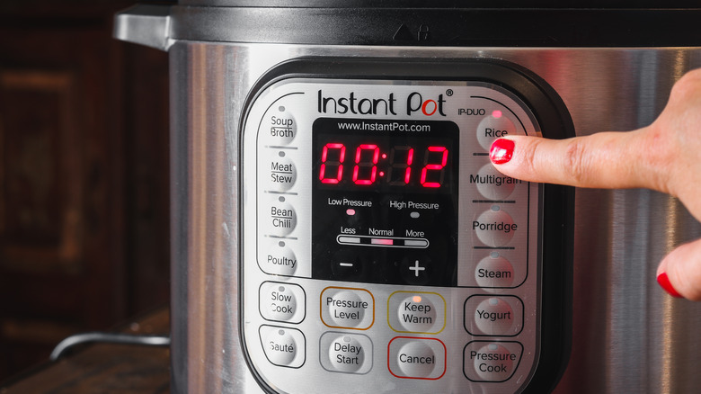 woman turning on Instant Pot