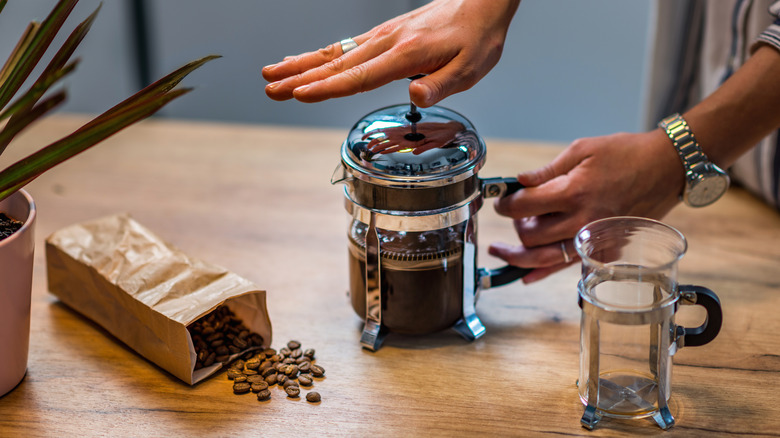 Whole coffee beans and French press