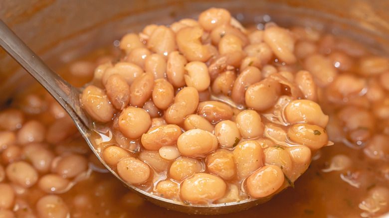 cooked pinto beans with ladle