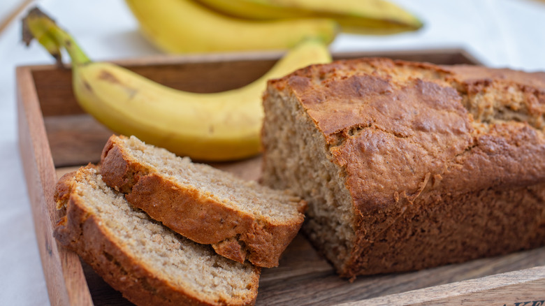 loaf of banana bread with unpeeled bananas 