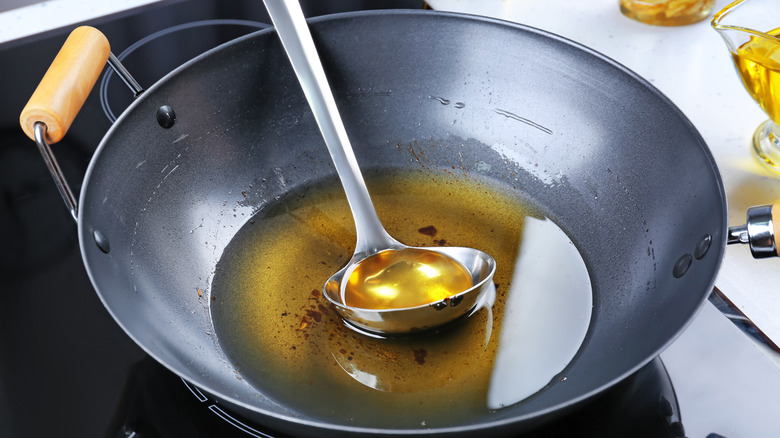 cooking oil and ladle in wok