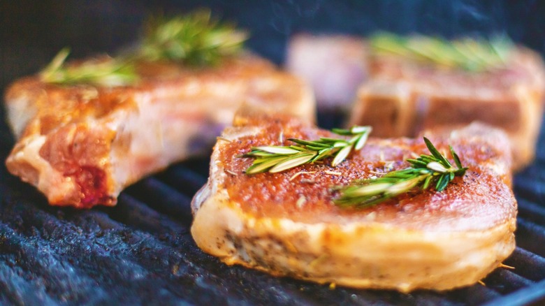 Pork chops on the grill with herbs on top