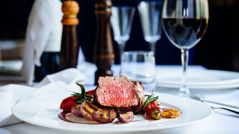 Plated steak and vegetables with a glass of wine