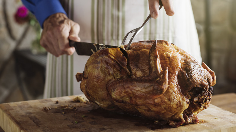 man slices into a thanksgiving turkey