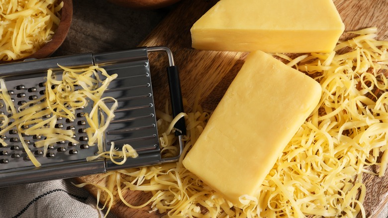 blocks of cheese sitting near grater