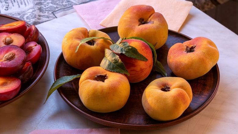 Peaches on wooden dish