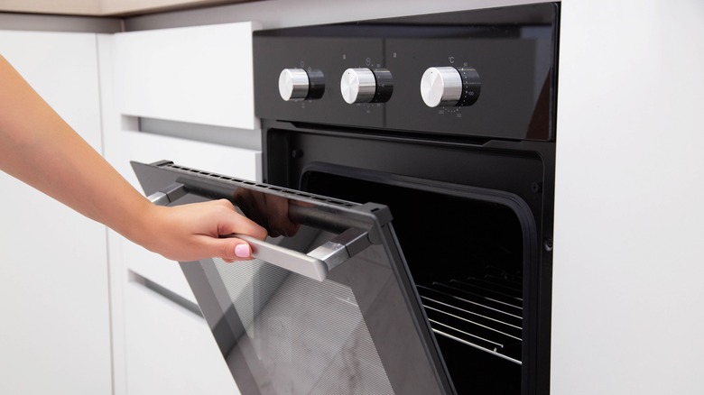 hand opens oven