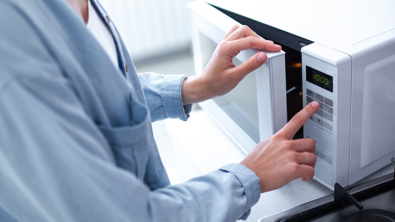 person setting microwave