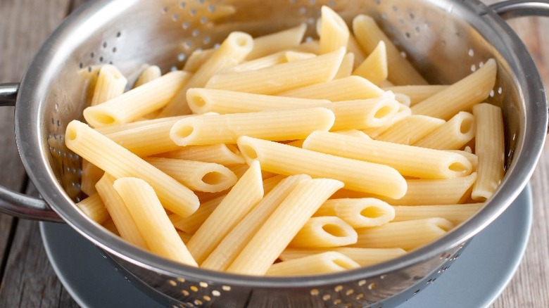 Plain penne pasta in colander 