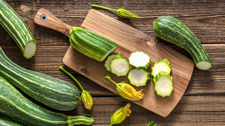 Zucchini and slices on cutting board