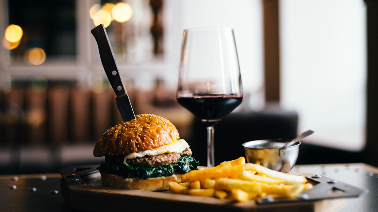 Burger, fries, and glass of red wine