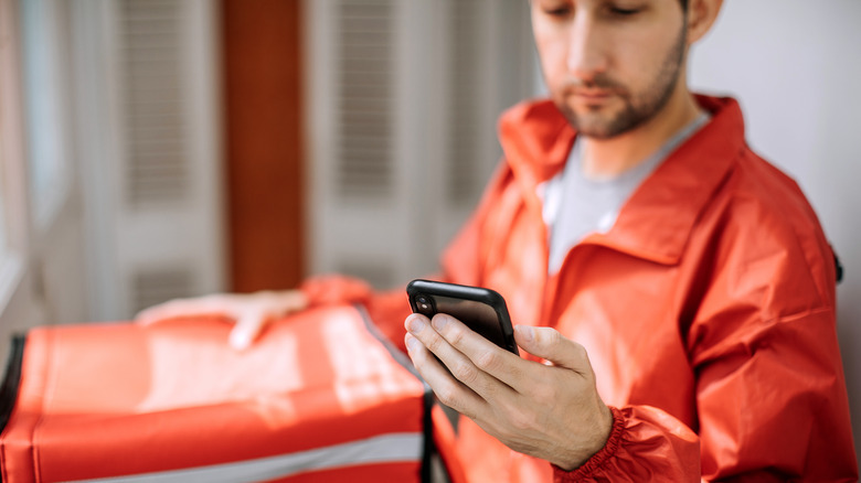 person on phone delivering food