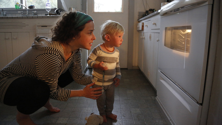 Parent and child looking at oven