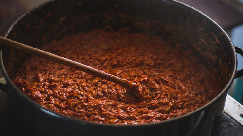 spoon stirring simmering pot of refried beans