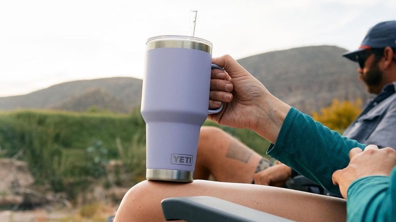 person holding purple Yeti Rambler