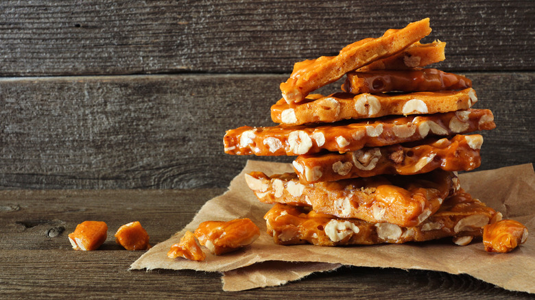 Shards of peanut brittle on brown paper