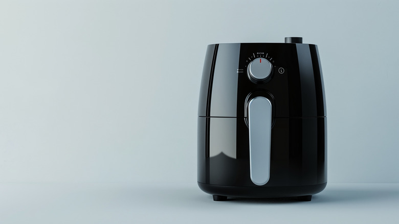 Air fryer on table with blue background