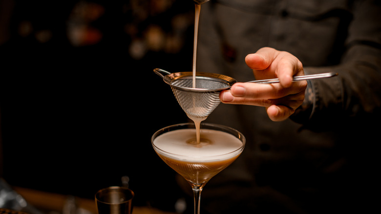 man straining espresso martini