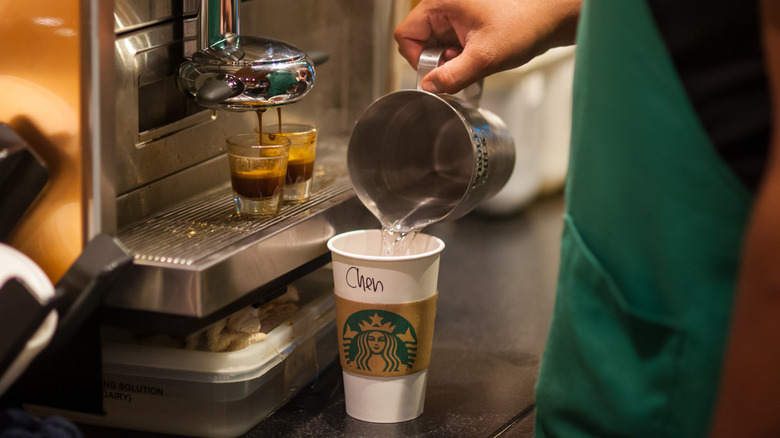Starbucks barista pouring water into cup