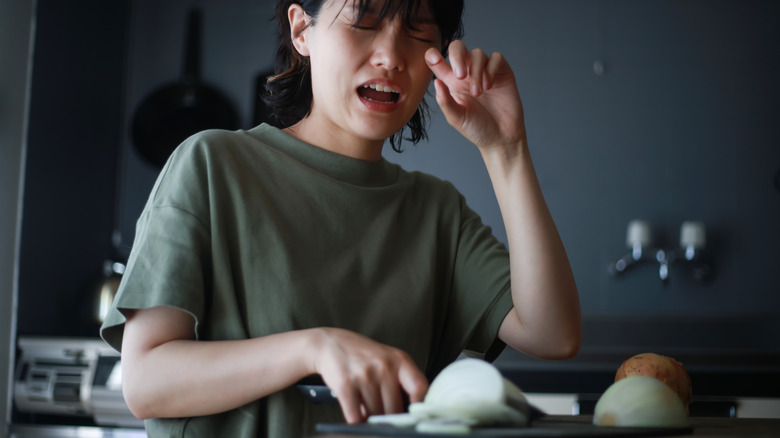 Woman crying cutting onions