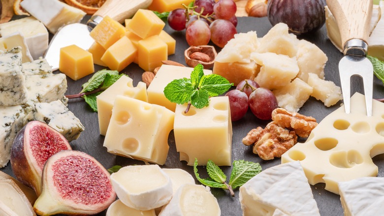 Board with cheese, fruits, nuts