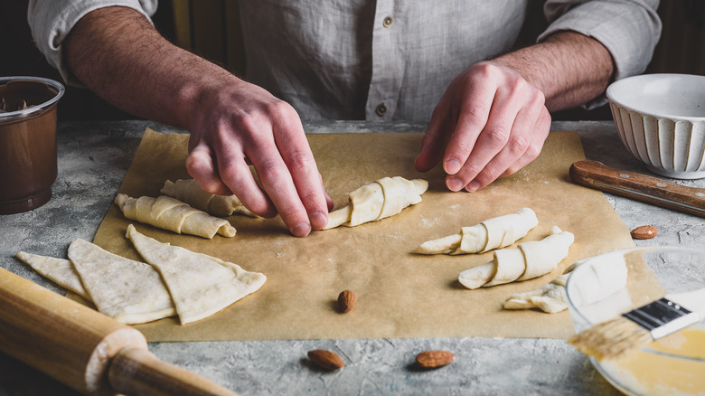 Hands rolling puff pastry dough