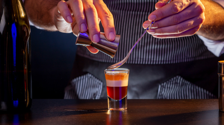 Bartender making layered B-52 shot