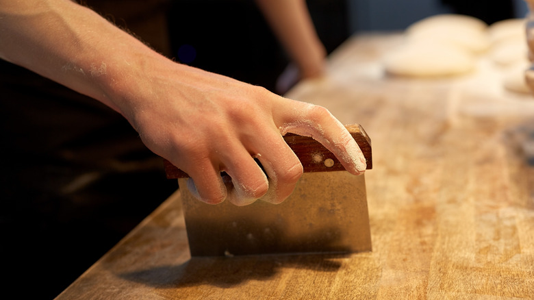 hand holding bench scraper