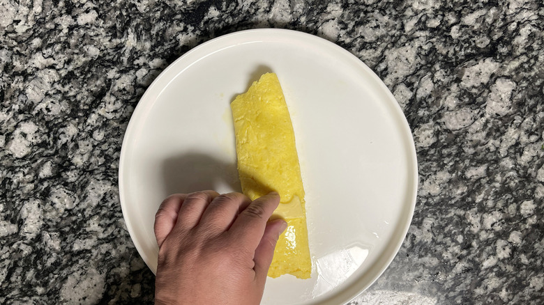 rubbing butter on omelette surface