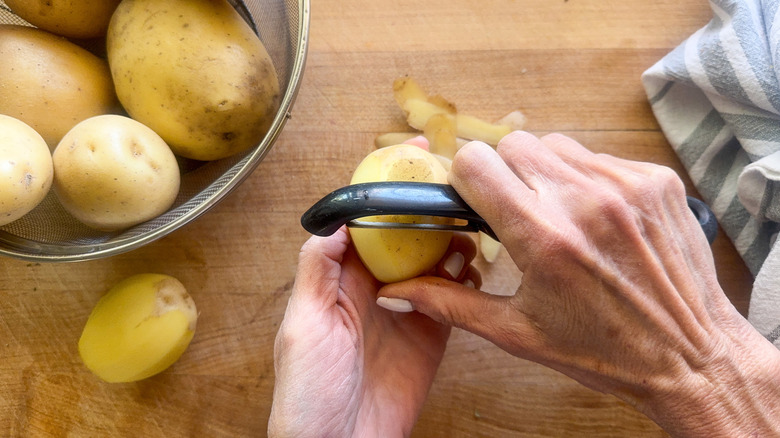 hands peeling potatoes