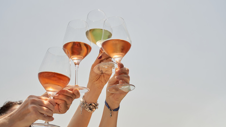 People holding wine glasses aloft