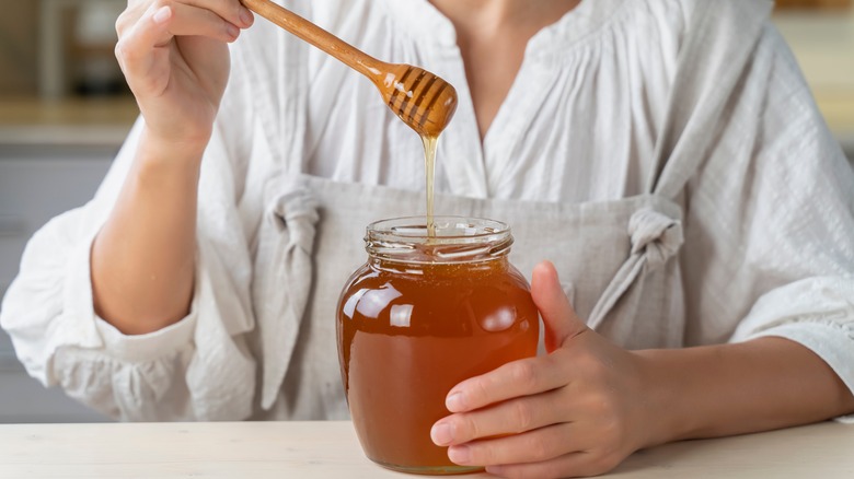 Jar of honey being held