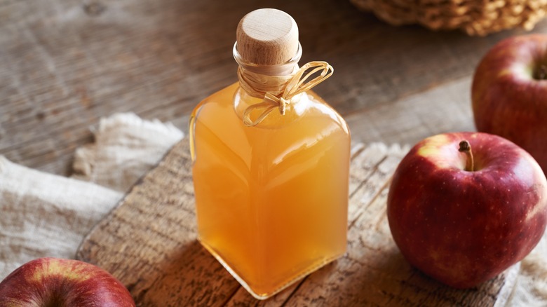 Apple cider vinegar jar and whole apples