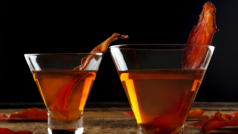 2 whiskey cocktails with bacon garnish