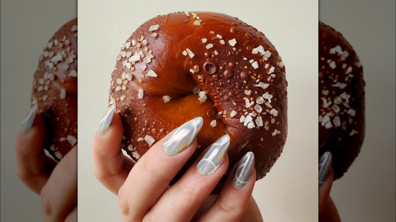 Hand holding pretzel bagel