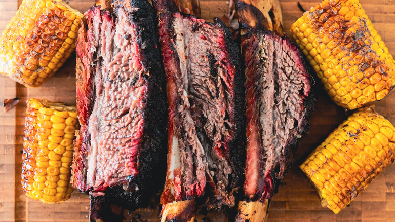 grilled beef ribs with corn on wooden board