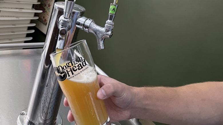 beer pouring from tap into Dogfish Head glass