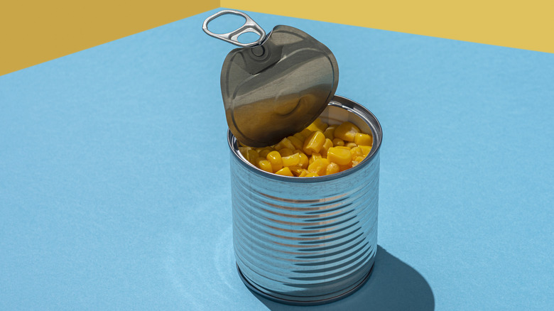 canned corn open on blue and yellow background