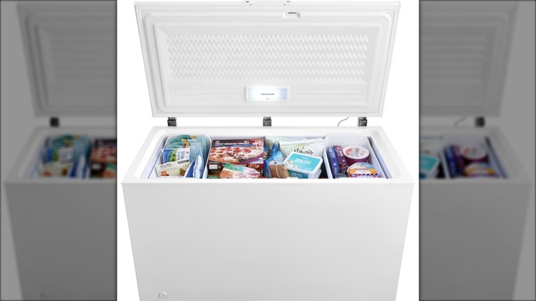 Frigidaire garage ready manual defrost chest freezer with frozen food inside on white background