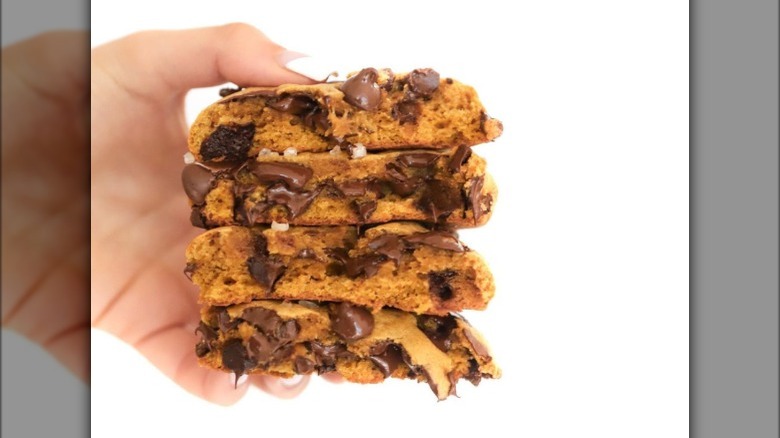 hand holding gooey chocolate chip cookies