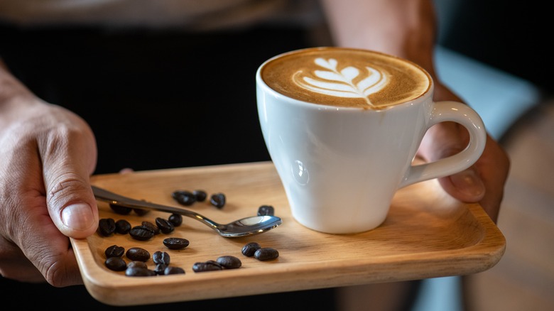 latte on a tray with coffee beans