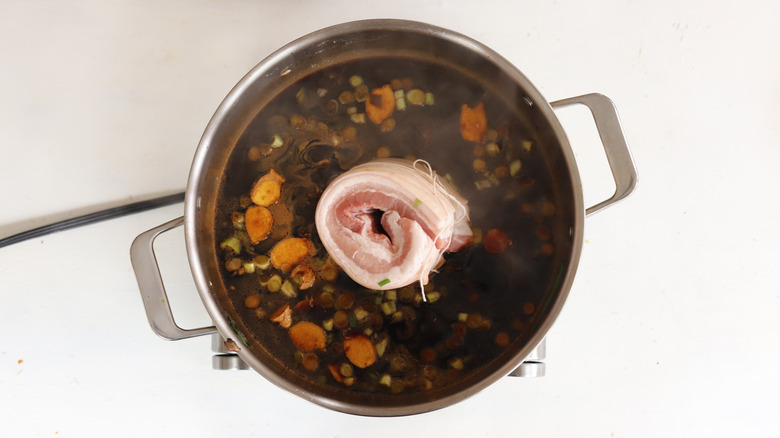 Rolled pork belly braising in a pot